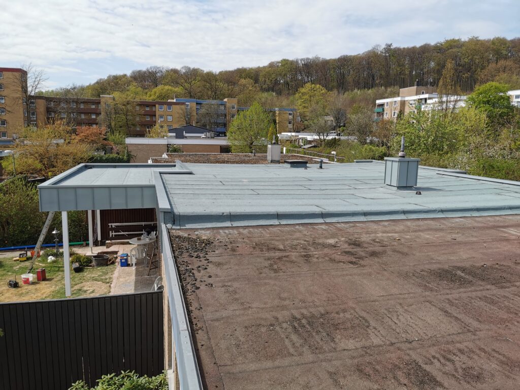 Städtische Wohngegend mit Flachdächern, Gartenmöbeln und Werkzeugen; ruhige, frühlingshafte Atmosphäre.