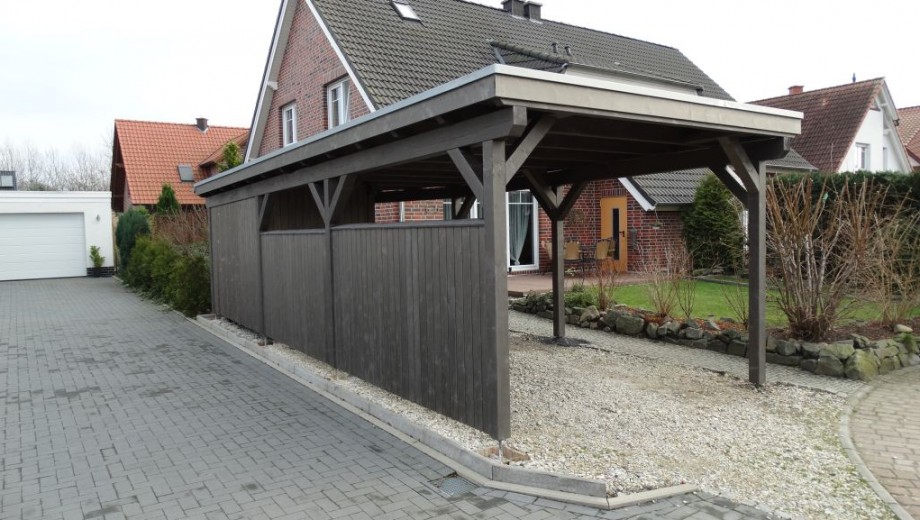 Ein ruhiges Wohngebiet mit einem Backsteinhaus, einem freistehenden Carport und gepflegtem Garten.
