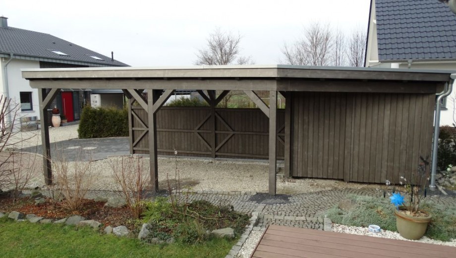 Ein hölzerner Carport in einer ruhigen Wohngegend mit gepflastertem Weg und bewölktem Himmel.