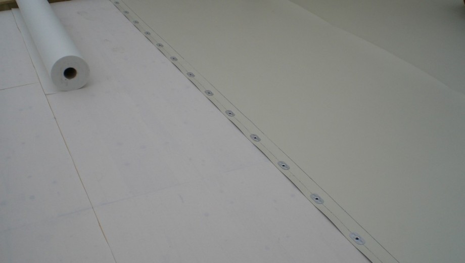Eine helle, glatte Oberfläche mit einer Rolle Material, vermutlich für Bau- oder Renovierungsarbeiten.