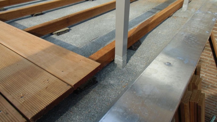 Holzterrasse im Bau mit parallel verlegten Bohlen und sichtbarer Metallunterkonstruktion.